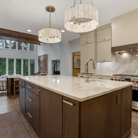 Two-tone kitchen cabinets with dark wood central island and light gray wall cabinets.